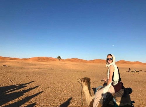 Cameron Hull riding a camel in the desert