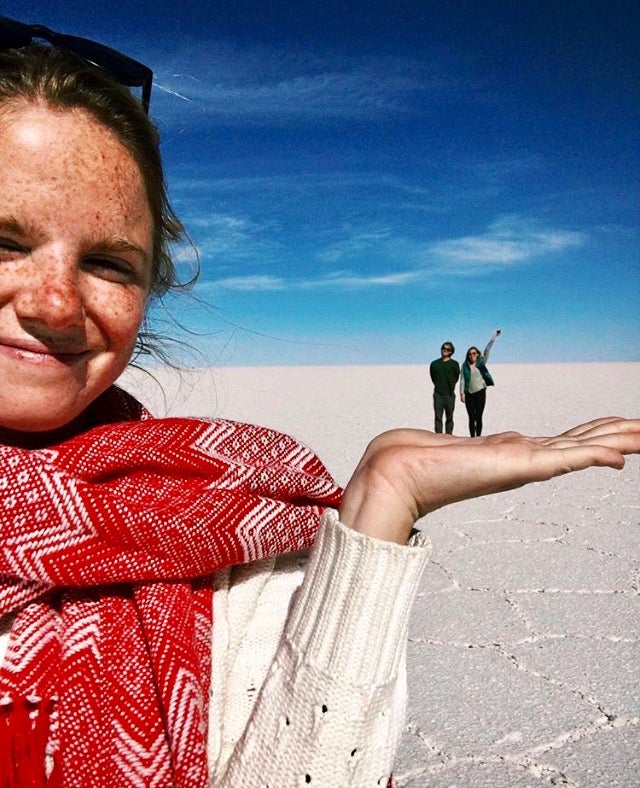 Woman in Chilean desert close to camera with two people standing in background