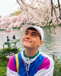 Samuel Boyne sits in front of cherry blossoms