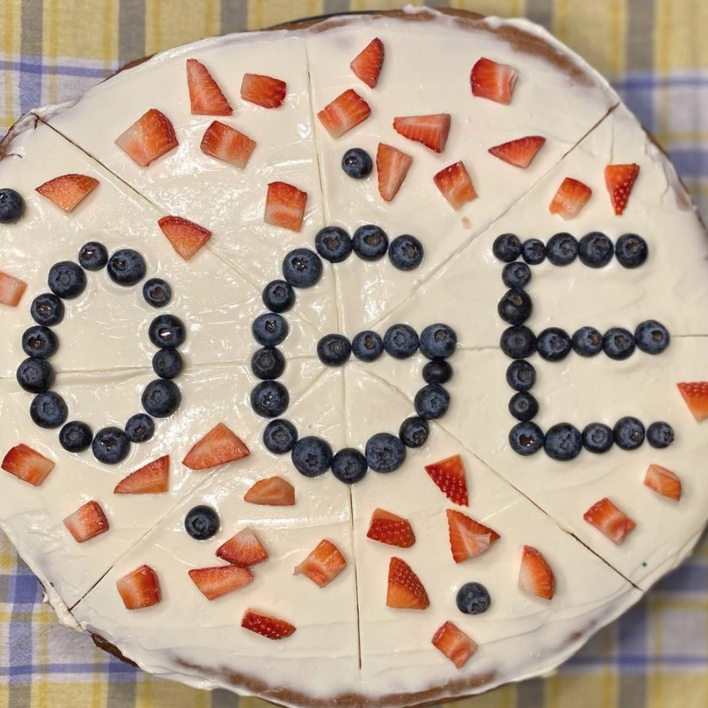 A dessert pizza featuring the letters OGE written in blueberries.