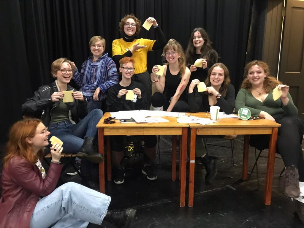 Nell and the entirety of her "Fresher's Family" are holding slices of cheese in the chair.