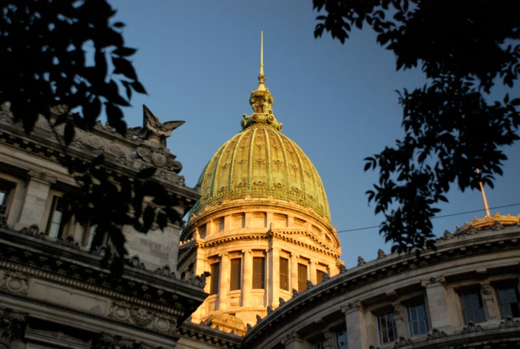 The dome of the Palace of the Argentine National Congress visible over two buildings.