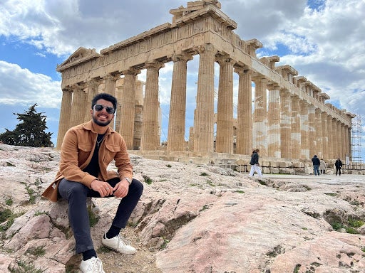 [Aditya Sehgal (SFS ‘24) in Acropolis, Greece during an academic excursion on SIT Switzerland: Banking, Finance, and Social Responsibility, in front of ancient ruins. 