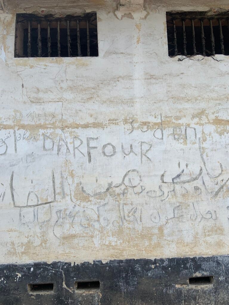 Sudanese refugee writing on the walls of Ussher Fort