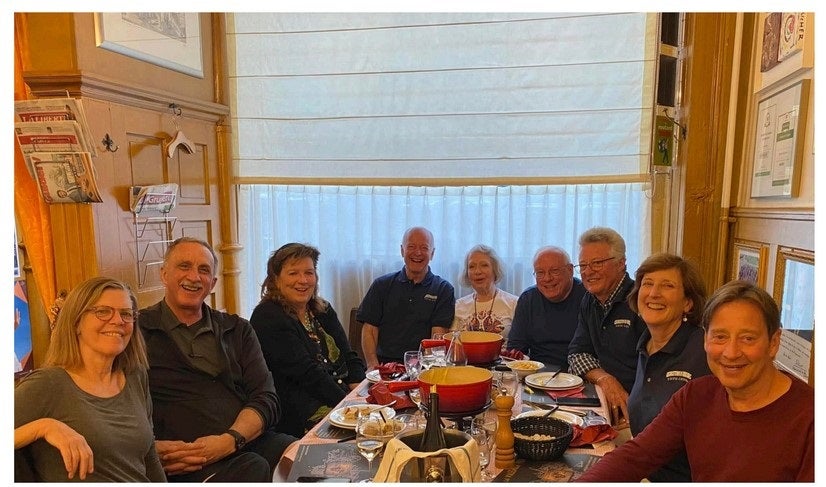 A group of people at a restaurant table smiling for a photo