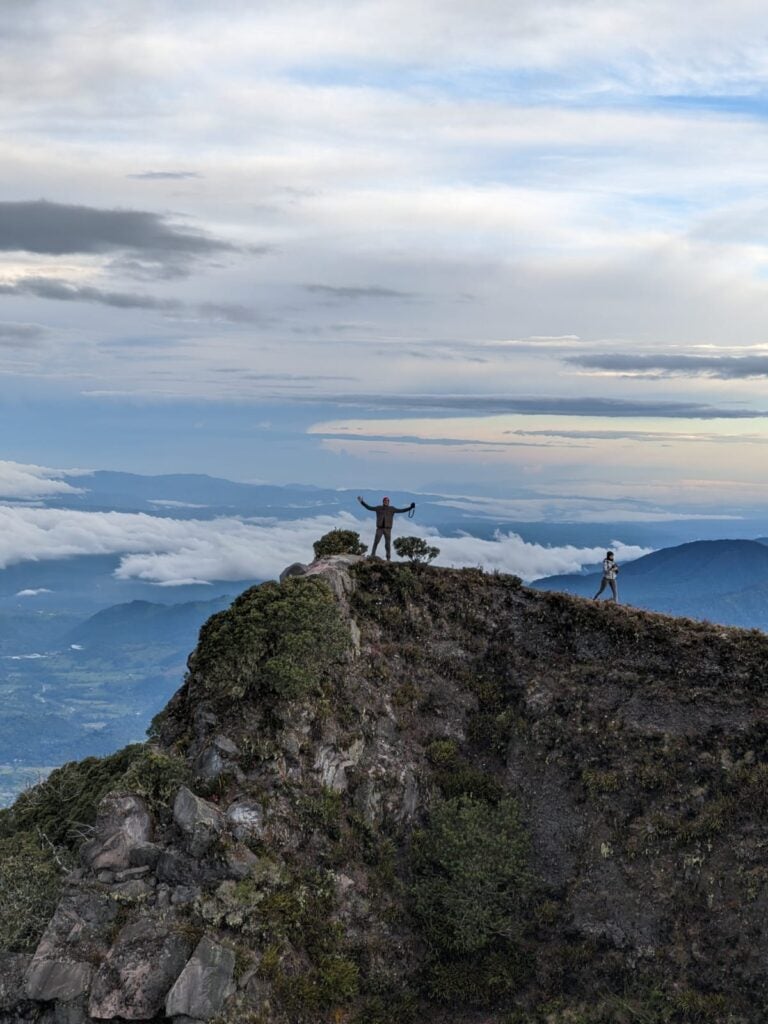 Man on top of cliff at Volcan Baru with the horizon behind him