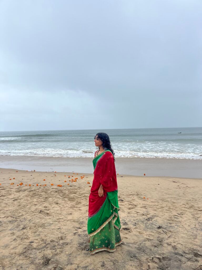 Girl stands in traditional Indian wear  on a beach