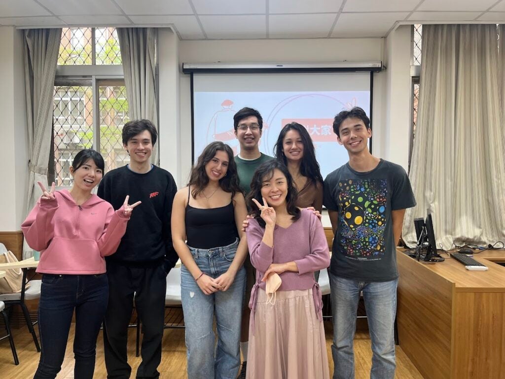 A group of 7 gathered for a group photo in a classroom