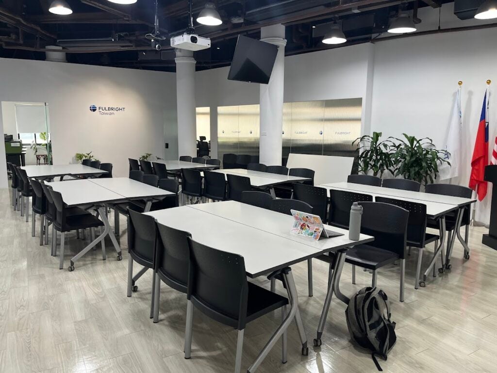 A room filled with white tables and black chairs