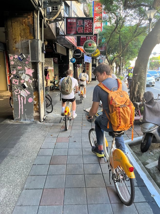 College students biking along a sidewalk to class