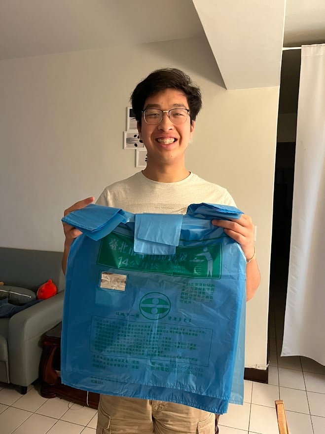 Jonathan holding up blue, plastic bags