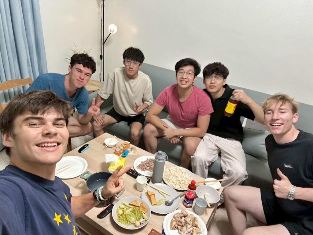 Group of boys in a living room with food on the coffee table, posing for a picture
