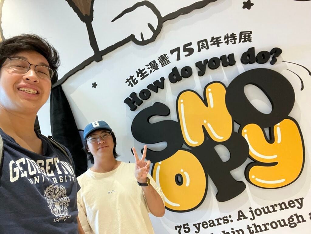 Two people in front of a "Snoopy" sign