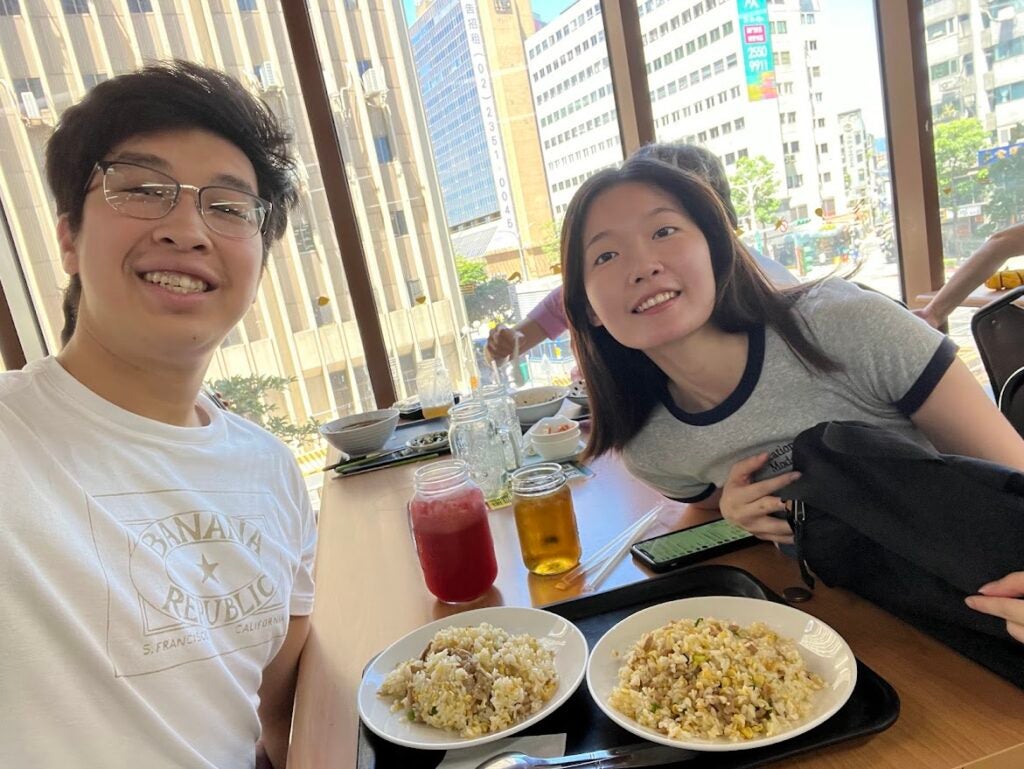 Two people across the table from each other with a meal